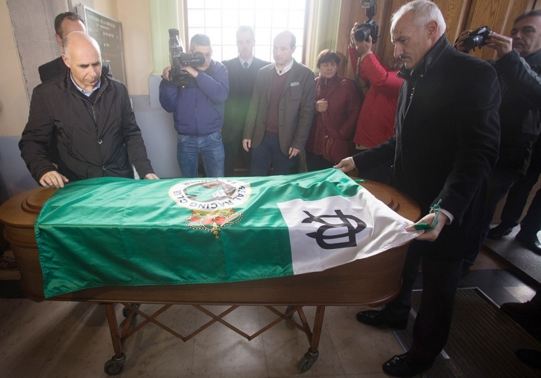 El presidente del club, Manolo Higuera, y el presidente de honor, Tuto Sañudo, ponen la bandera del Racing en el ataúd de Nando Yosu (2016).